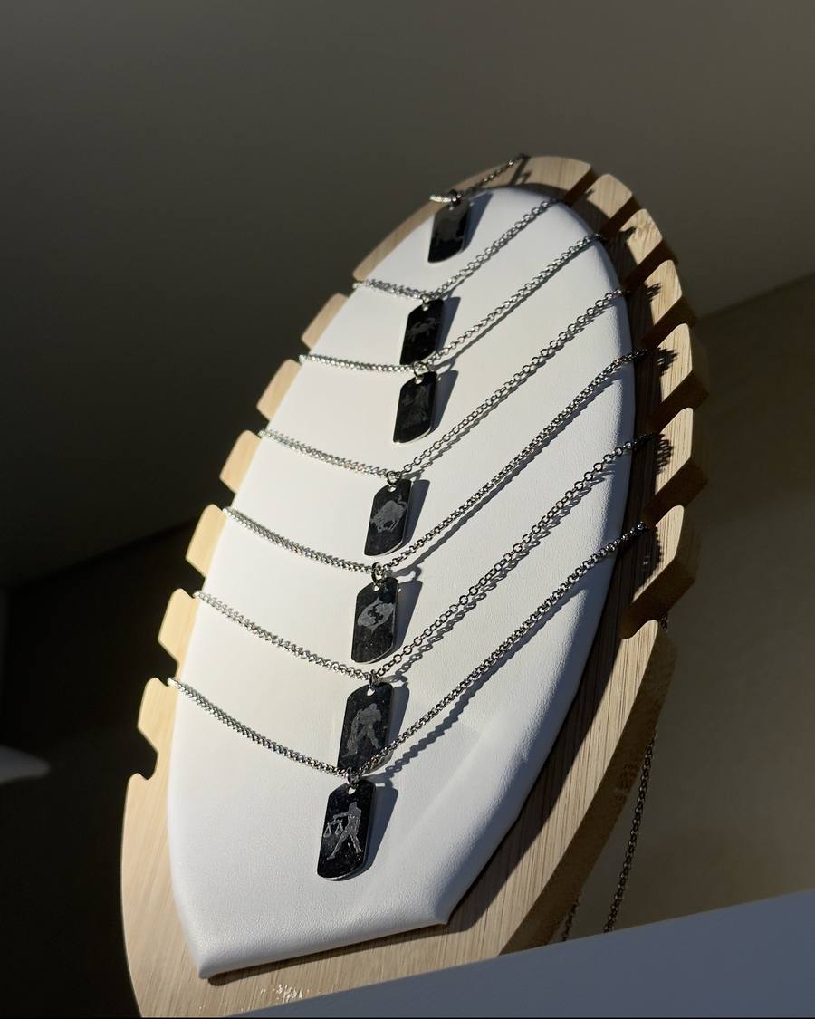 Pendentifs gravés des signes du zodiaque sur leur présentoir
